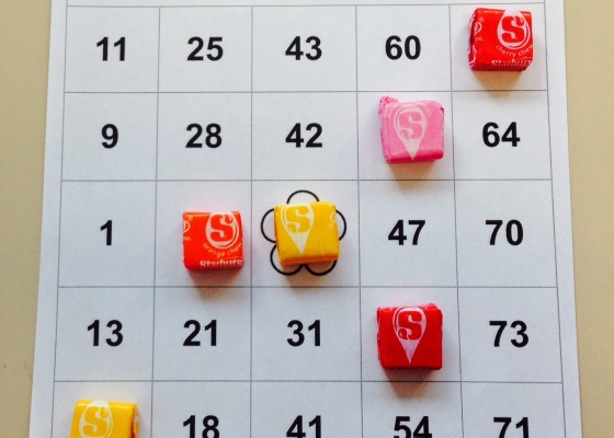 Wrapped Starburst candy are used as markers on a bingo card.