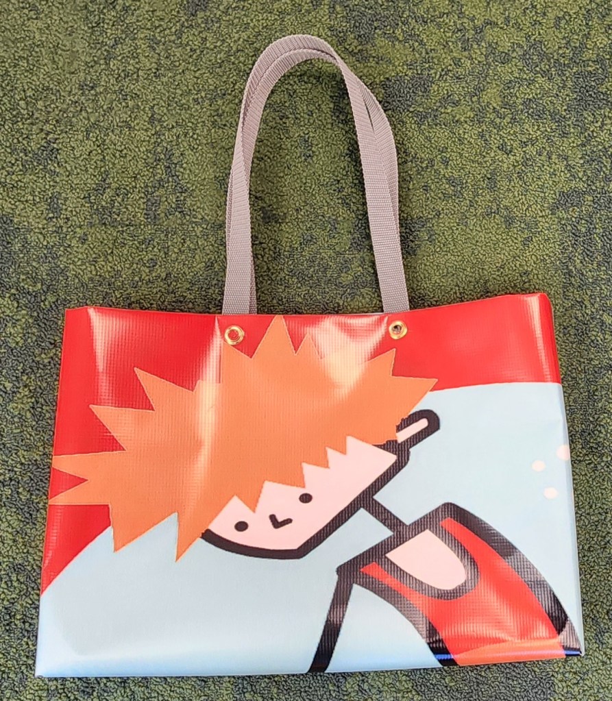 Photo of a bag made out of an old banner, with handles.